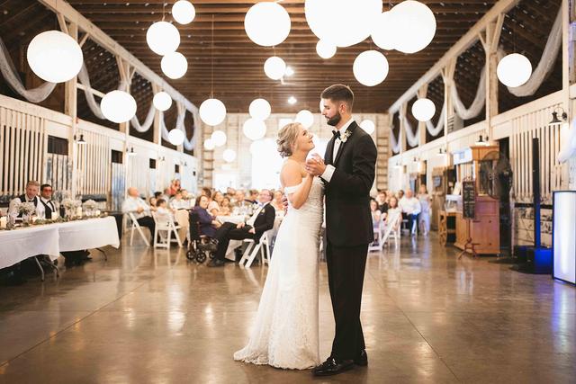 Couple's first dance under paper lanterns in the barn