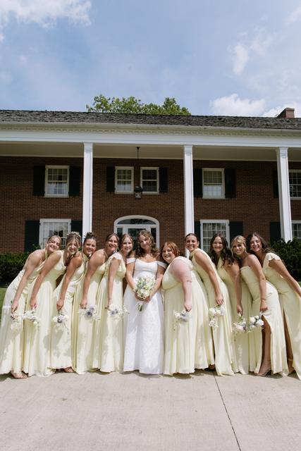 Bride and bridesmaids in front of the columned brick house