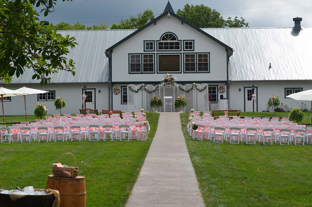 outdoor wedding seating in front of white barn