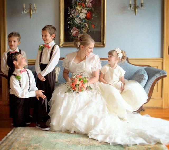bride on couch with three boys and a girl