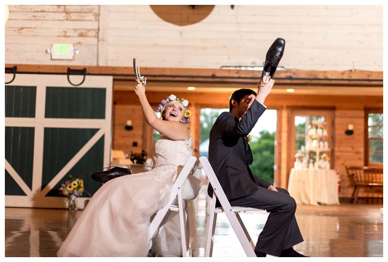 bride in groom in chairs holding shoes