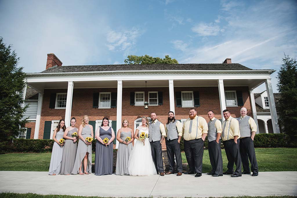 wedding party in front of a brick house