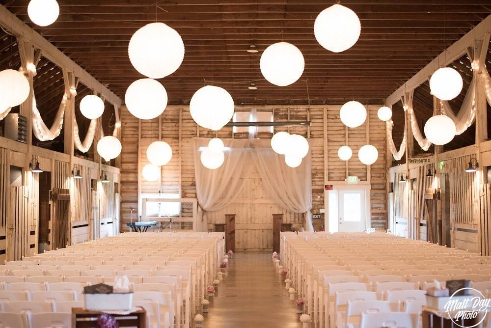 Ceremony aisle inside the barn under paper lanterns