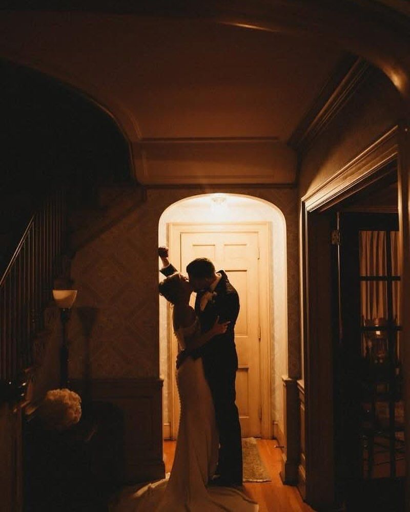 Couple kissing in silhouette in a doorway of the house