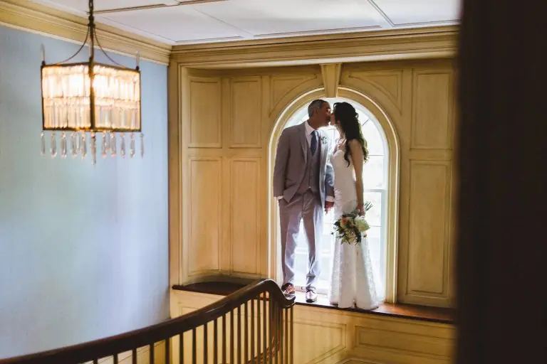 Couple kissing in the arched window of the house stairwell