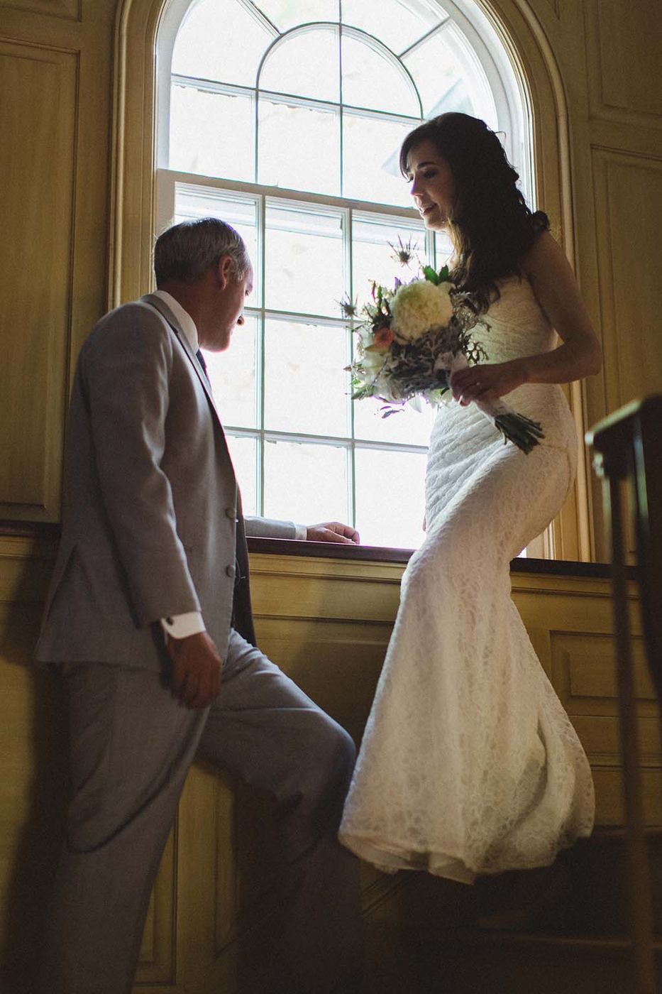 Bride and groom by the tall house window