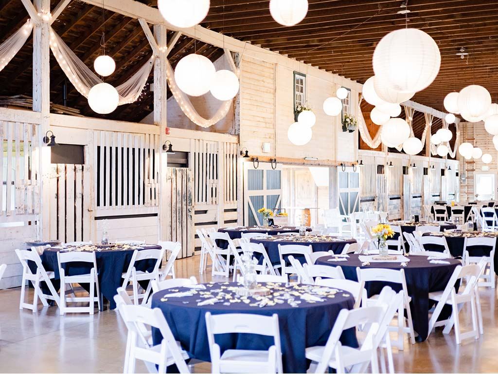 Barn reception with navy tablecloths and sunflower centerpieces